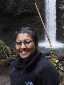 Neha in front of a waterfall.